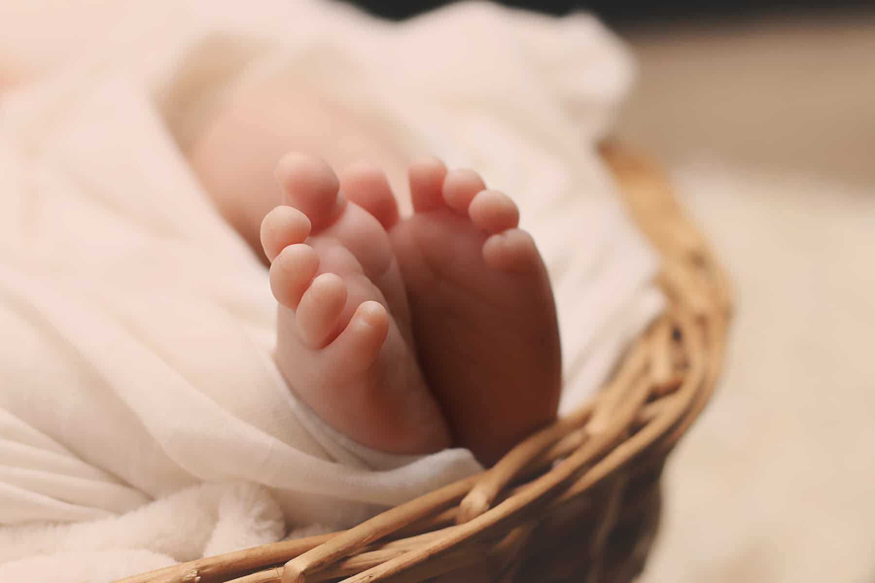 baby s feet on brown wicker basket | Baby Names that Start with a J